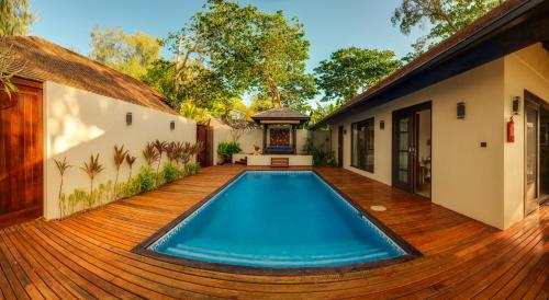uma piscina num deque de madeira ao lado de uma casa em Warwick Le Lagon Resort & Spa, Vanuatu em Port Vila