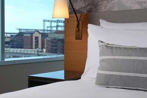 a bed with a view of a city from a window at Hotel Indigo Denver Downtown - Union Station by IHG in Denver
