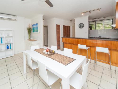 a white dining room with a white table and chairs at Hamilton Island Holiday Homes in Hamilton Island