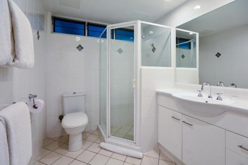 a bathroom with a shower and a toilet and a sink at Hamilton Island Holiday Homes in Hamilton Island