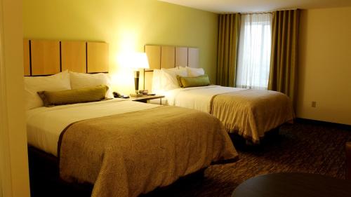 a hotel room with two beds and a window at Candlewood Suites Sioux City - Southern Hills, an IHG Hotel in Sioux City
