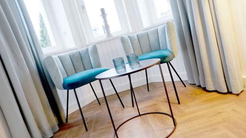a group of chairs and a table in front of a window at BUITERLING Hotel in Brilon