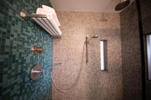 a bathroom with a shower with green tiles at Modern Hotel in Boise