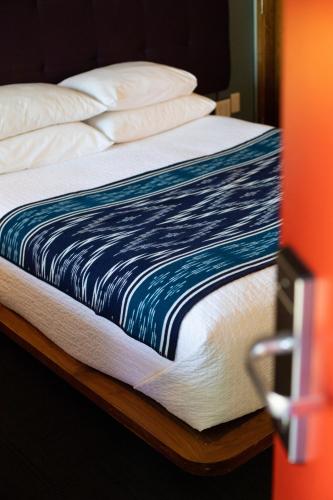 a bed with a blue and white blanket on it at Modern Hotel in Boise