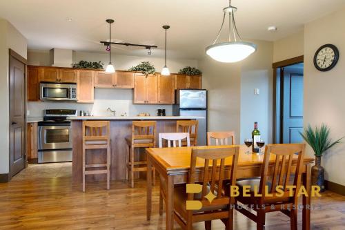 a kitchen and dining room with a wooden table and chairs at Palliser Lodge — Bellstar Hotels & Resorts in Golden