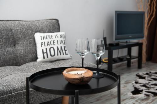 a living room with a table and two wine glasses at Business sky Loft in Sofia