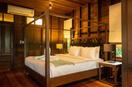 1 dormitorio con cama con dosel en una habitación en Baan Suan Ramita Resort, en Chanthaburi
