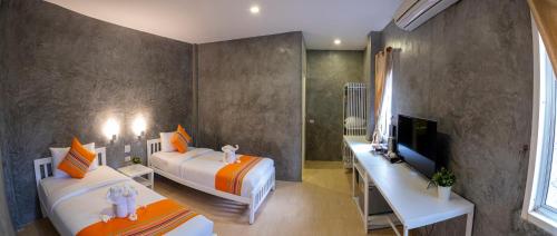 a hotel room with two beds and a television and a room at Ban's Avenue Guesthouse in Koh Tao
