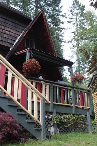 a porch of a house with flowers on it at Sunny Bluffs Chalets in Kaslo