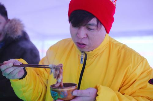 a woman in a red hat eating food with a chopstick at Shangri-La Manzhouli in Manzhouli
