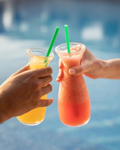 two people holding two drinks in their hands at Novotel Sharjah Expo Centre in Sharjah