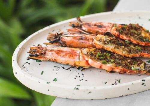 a plate of lobsters with herbs on it at Potato Head Suites & Studios in Seminyak
