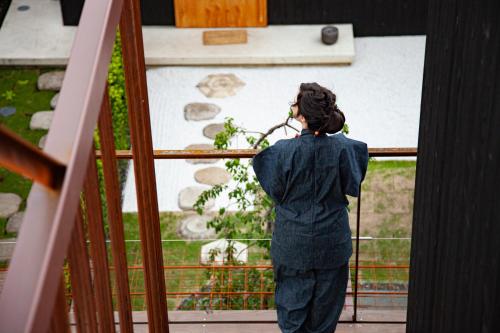 a woman looking out the window of a building at modern ryokan kishi-ke in Kamakura
