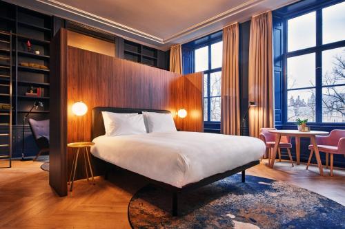 Habitación de hotel con cama, mesa y sillas en Staybridge Suites The Hague - Parliament, an IHG Hotel, en La Haya