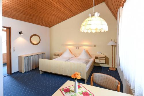 a hotel room with a bed and a table at Pension Neustart in Bad Buchau