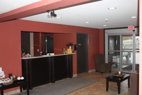 a bar in a room with red walls at Western Star Inn & Suites Esterhazy in Esterhazy