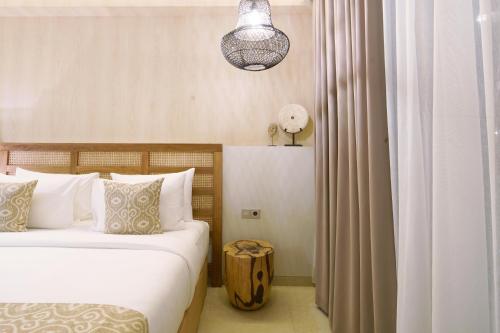 a bedroom with a bed with white sheets and pillows at Umah Tirta in Ubud