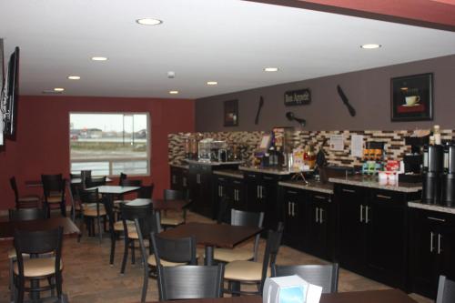 a restaurant with tables and chairs and a bar at Western Star Inn & Suites Esterhazy in Esterhazy