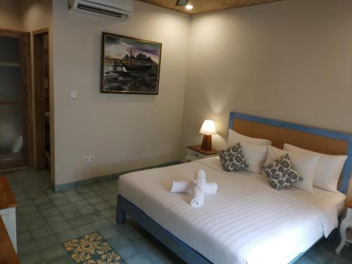 a bedroom with a bed with a teddy bear on it at Jukung Guest House in Sanur