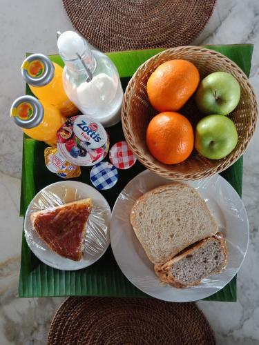 珍南海滩Bon Ton Antique Wooden Villas的桌子上放着两篮水果和一个三明治