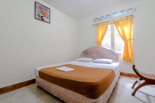 a bedroom with a bed and a window at Hotel Kayu Manis in Kaliurang