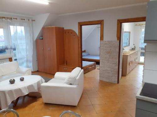 a living room with a white couch and a table at Mazurskie Wzgórze Apartament in Rydzewo