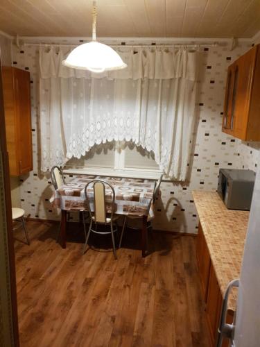 cocina con mesa, sillas y ventana en Apartment on 700-letiya Kobrina 4, en Kobryn