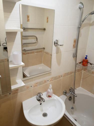 a bathroom with a sink and a shower with a mirror at Apartment on 700-letiya Kobrina 4 in Kobryn