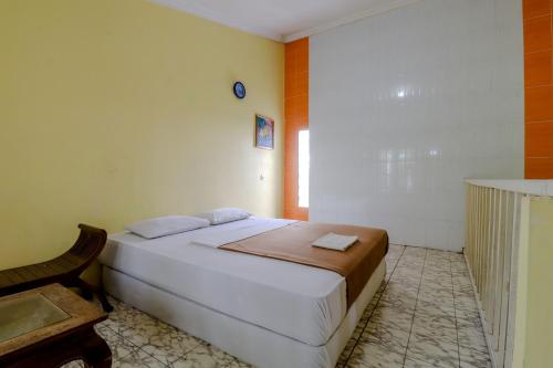 a bedroom with a white bed in a room at Hotel Kayu Manis in Kaliurang