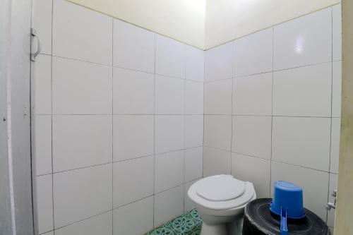 a white bathroom with a toilet and a trash can at Hotel Kayu Manis in Kaliurang