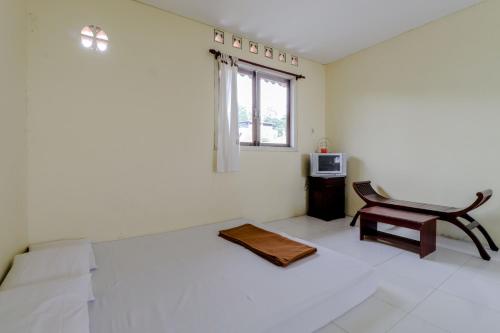 a living room with a chair and a table at Hotel Kayu Manis in Kaliurang