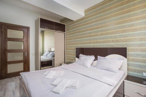 sypialnia z dużym białym łóżkiem z ręcznikami w obiekcie Stay Inn Apartments at Mashtots avenue 33-1 w Erywaniu