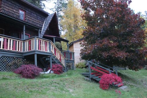 a house with a porch and a bench in the yard at Sunny Bluffs Chalets in Kaslo
