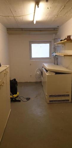 an empty room with a kitchen with a window at Ferienwohnung Quednau in Grafenau