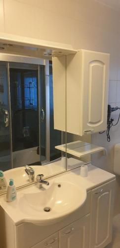 a bathroom with a white sink and a mirror at Ferienwohnung Quednau in Grafenau