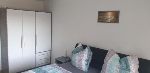 a bedroom with a bed and a white cabinet at Ferienwohnung Quednau in Grafenau