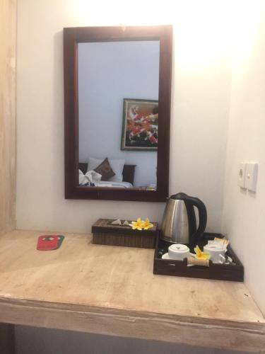 uno specchio sopra un tavolo con bollitore per il tè di Isola D'oro lembongan a Nusa Lembongan
