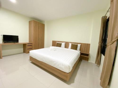 Nai Yang Residence في شاطئ ناي يانغ: غرفة نوم بسرير كبير وتلفزيون
