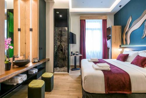 ein Hotelzimmer mit einem großen Bett und einem Bad in der Unterkunft Artion Boutique by Enorme in Iraklio