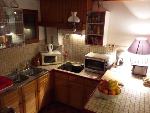 a kitchen with a microwave and a bowl of fruit on the counter at Gite Prat de sempé in Vignec