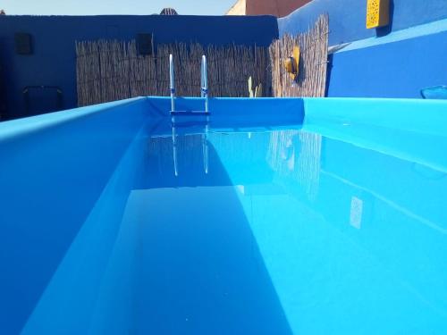 una piscina azul con dos postes en el agua en Riad Zinnha, en Marrakech