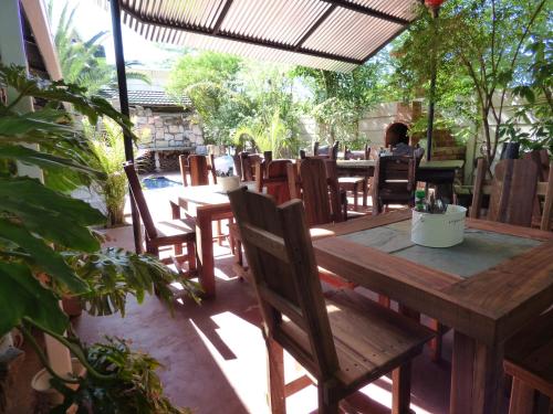 ツメブにあるVilla Africa Guesthouseのパティオにある木製のテーブルと椅子