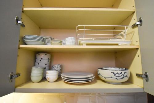 a yellow cabinet with plates and bowls and dishes at 伊豆稲取テラス-寛道- in Shimoda