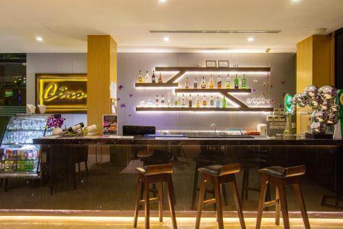 um bar com quatro bancos num restaurante em Hotel Icon Bangkok Sukhumvit 2 em Banguecoque