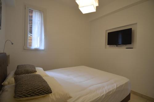 - une chambre avec un lit et une télévision à écran plat dans l'établissement Appartement 4 personnes grande terrasse dans le Carré d Or à Nice, à Nice