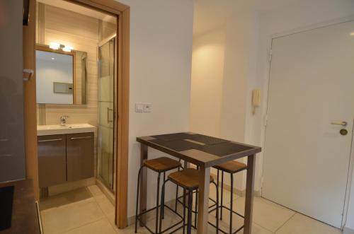 La salle de bains est pourvue d'un lavabo et d'un comptoir avec tabourets. dans l'établissement Appartement 4 personnes grande terrasse dans le Carré d Or à Nice, à Nice