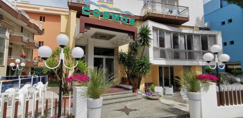 a hotel with plants in front of a building at Hotel Cosmos in Rimini