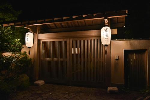 a japanese gate with two lanterns on top at night at 伊豆稲取テラス-寛道- in Shimoda