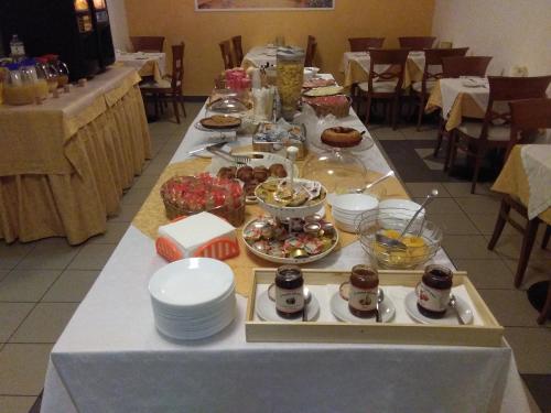 a long table with food on it in a restaurant at Hotel Rocco in Carugate