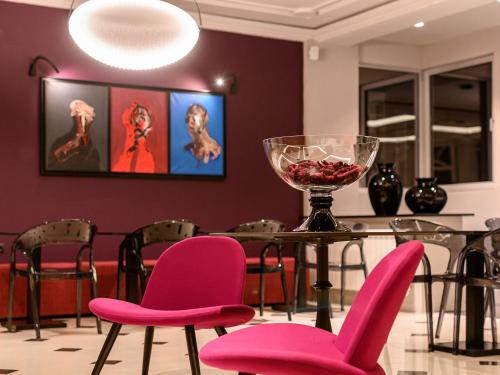 尼什的住宿－嘉尼藝術洛夫特酒店，用餐室配有粉红色的椅子和桌子